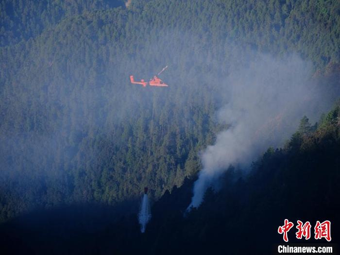 直升机在木里火场实施吊桶洒水灭火作业。　程雪力 摄