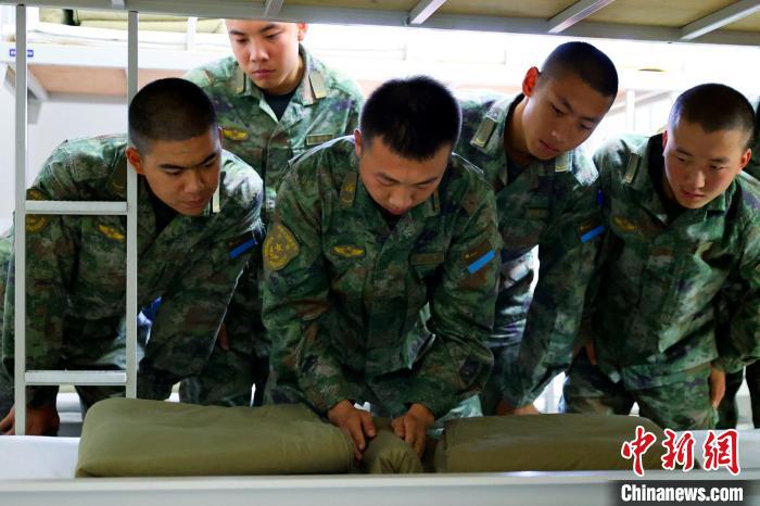 图为下连后班长教新兵叠被子。　华蕊 摄