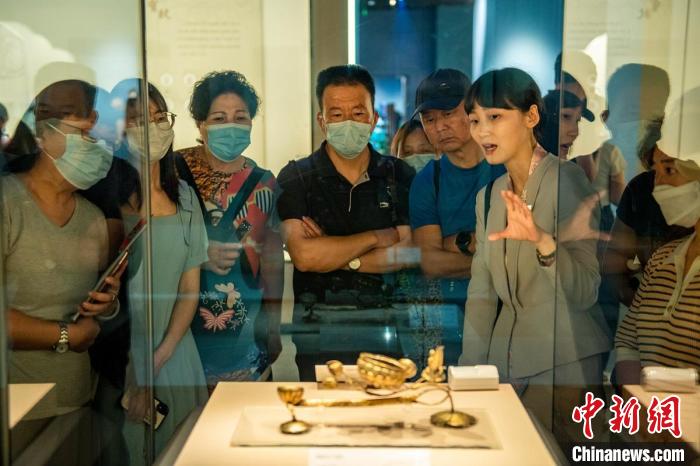 講解員向參觀者介紹宋代銀質鎏金蓮花寶子香爐展品。　劉忠俊 攝