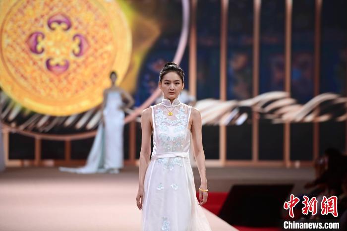 模特现场展示燕京八绝传统技艺与梦金园品牌合作打造的一款黄金吊坠 田雨昊 摄