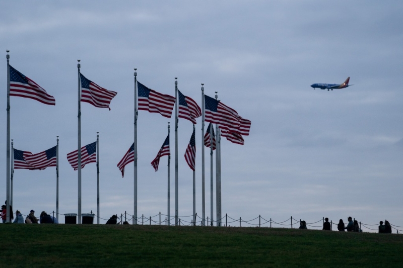2022年11月10日，在美国首都华盛顿，一架飞机从美国国旗上空飞过。（图源：新华网）