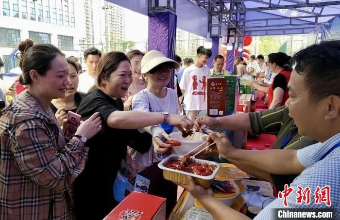 图为江西南昌英雄城啤酒龙虾烧烤节上，游客争相品尝铁河小龙虾预制菜。　新建区融媒体中心供图