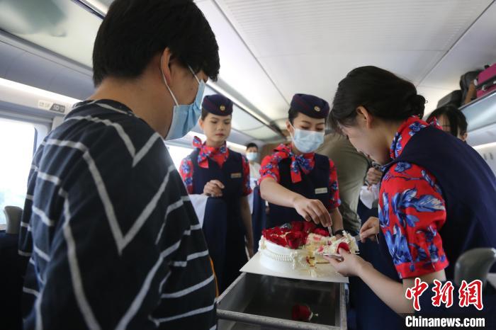 乘务员与旅客分享生日蛋糕。　周晓阳 摄