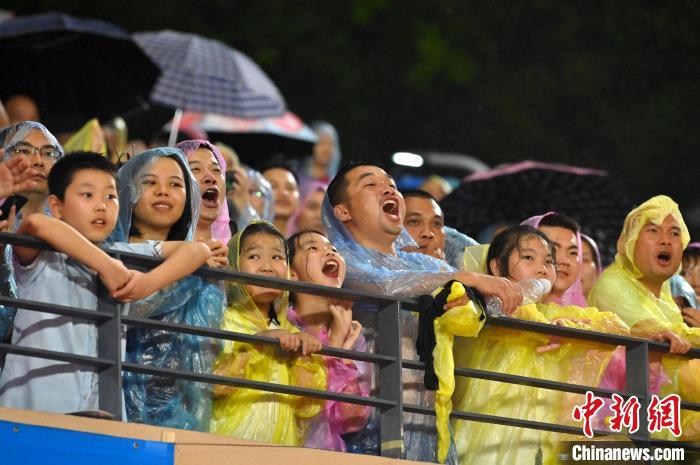球迷冒雨观赛，大声呐喊助威。　俞靖 摄
