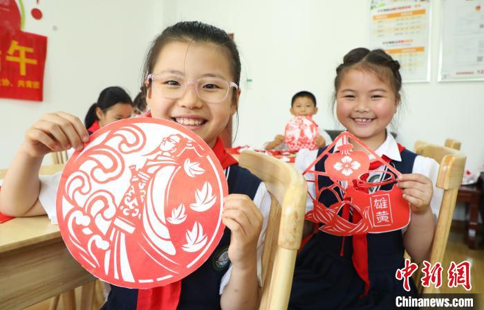 安徽省肥西县上派镇四十埠社区服务中心里，小学生们展示自己的剪纸作品。　陈家乐 摄