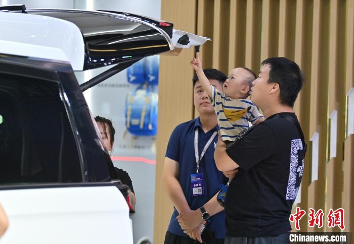 一位小朋友在好奇地查看后备箱车门。　张瑶 摄