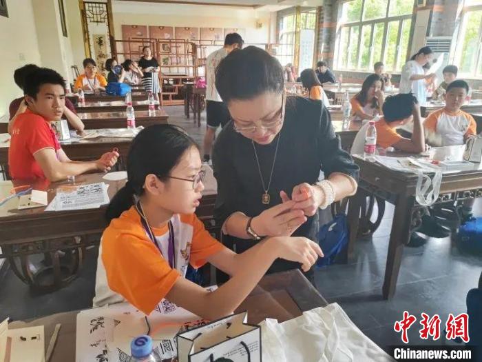 珊丽娜指导华裔少年做盘扣。　上海市侨联供图