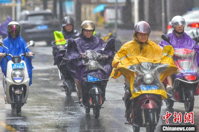 图为海口民众在雨中骑行。　骆云飞 摄