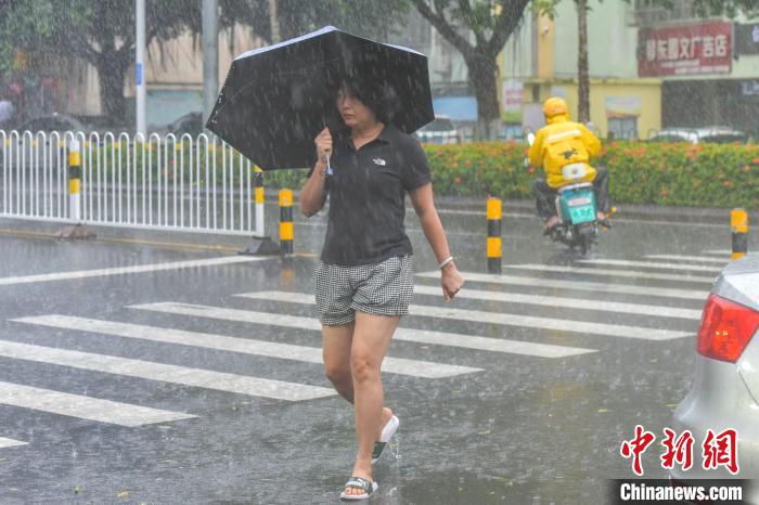 图为海口市民冒雨出行。　骆云飞 摄