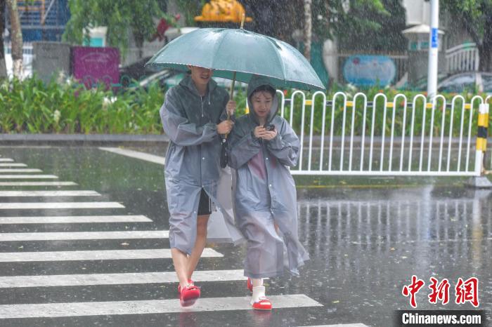 图为海口市民冒雨出行。　骆云飞 摄