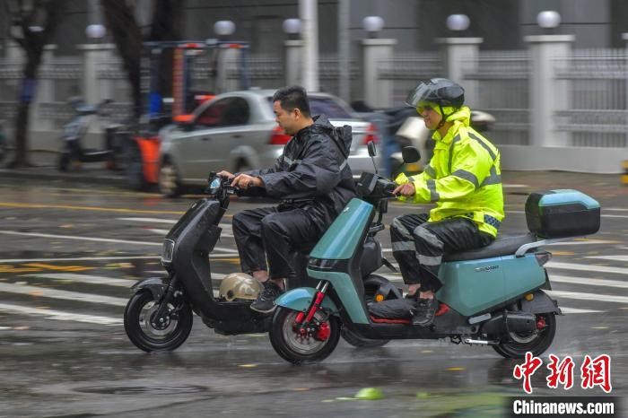 图为海口市民冒雨出行。　骆云飞 摄