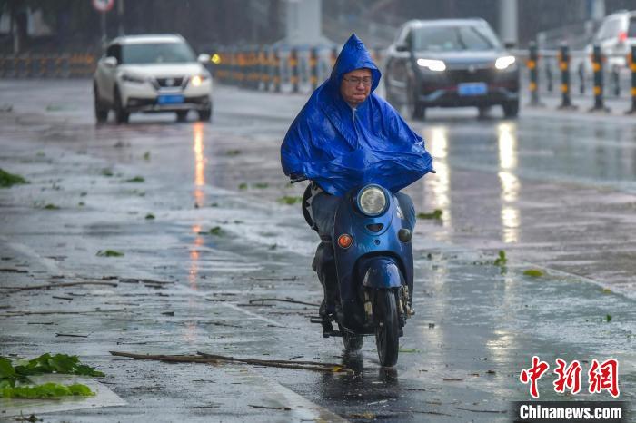 图为海口市民冒雨出行。　骆云飞 摄