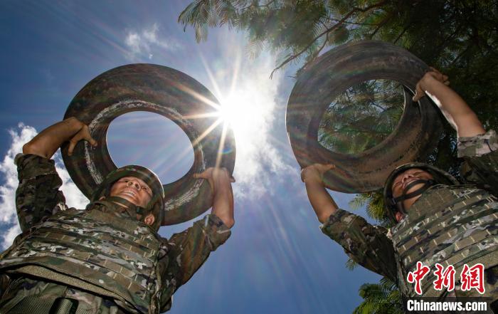 武警官兵在进行推举轮胎训练。　梁承杰 摄