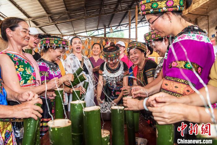 图为当地瑶族、壮族民众一起做竹筒饭。　蓝洲 摄