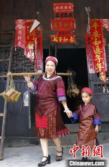 施秉县杨柳塘镇陆地坪苗寨苗族女同胞带着包好的粽粑串门。　奉力 摄