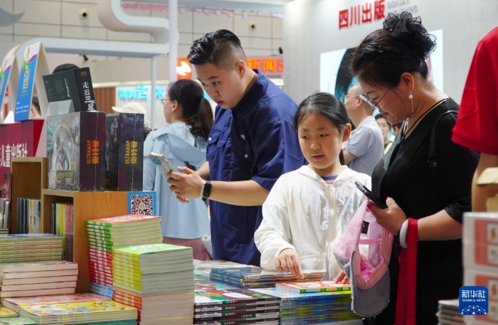 7月27日，在第31届全国图书交易博览会上，读者在阅览新书。新华社记者 徐速绘 摄