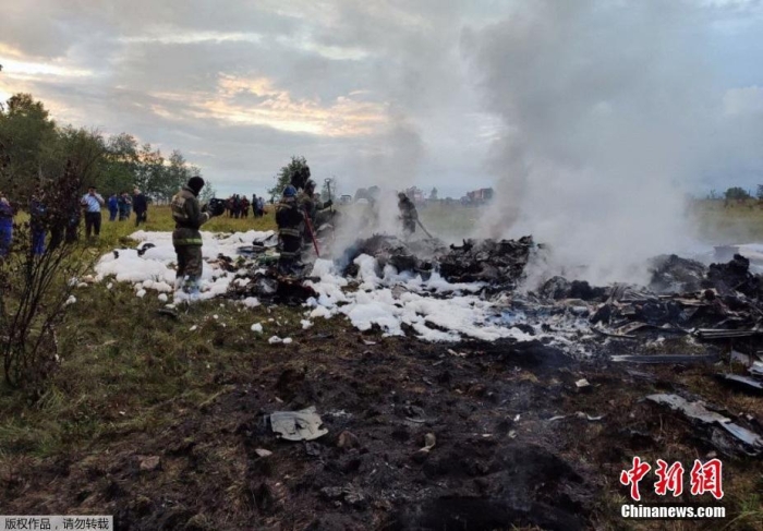 图为当地时间8月23日，俄罗斯特维尔州，救援人员在区库仁基诺村附近的飞机坠毁现场工作。