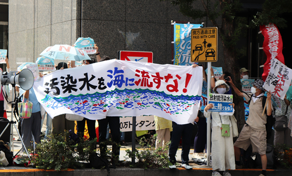8月24日，日本民众手持“不许将污染水排入大海”等标语在东京电力公司总部前集会，抗议日本政府和东电公司无视民意启动核污染水排海。（图源：新华网）