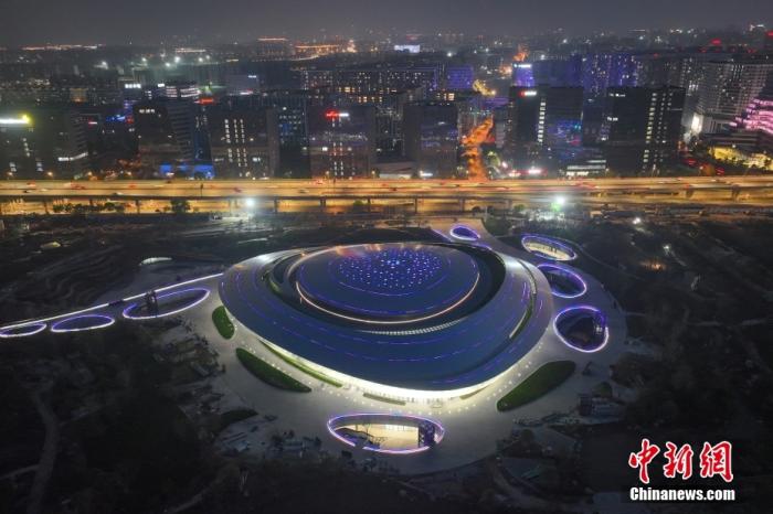 资料图：杭州2022年亚运会电子竞技场馆入夜亮灯，屋顶彩色光条如星轨。(无人机照片) 中新社记者 王刚 摄