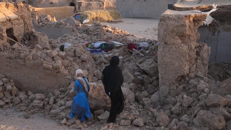 10月7日，人们站在阿富汗赫拉特省震后坍塌的房屋旁。新华社发（马沙勒摄）