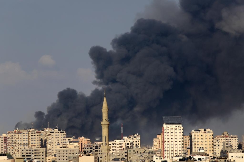 10月11日，加沙城的建筑遭以色列空袭后升起浓烟。（图源：新华社）