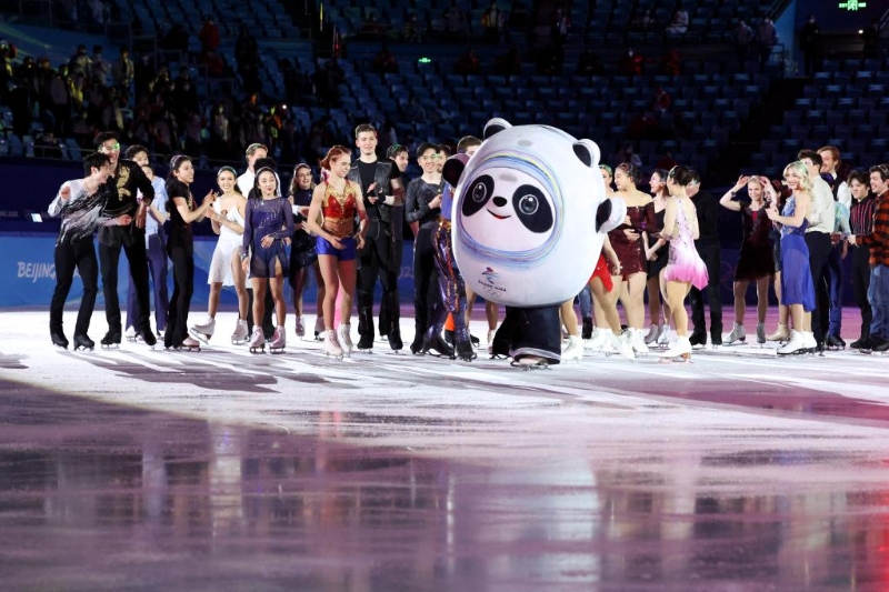2月20日，选手们在表演滑结束后与“冰墩墩”互动。当日，北京2022年冬奥会花样滑冰表演滑在首都体育馆举行。（图源：新华社）
