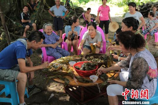 资料图为：李美金老人请吃粽子。