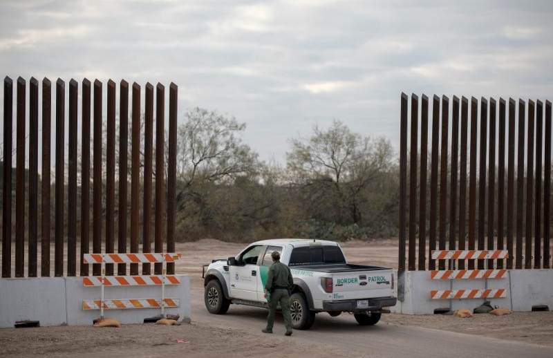 2022年1月7日，在美国得克萨斯州边境城市伊格尔帕斯，巡逻人员走在新建的边境墙边。（图源：新华社）