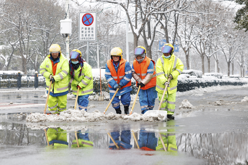 2月4日，在江苏省宿迁市泗洪县泗州大街，工作人员在清扫路面积雪。（图源：新华社）