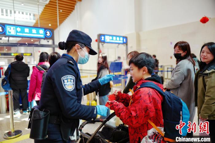 2月10日，福州出入境边防检查站移民管理警察向入境台胞赠送中国结。　杨馨 摄