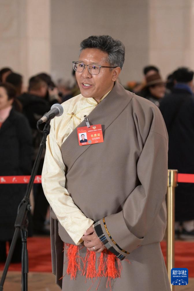 3月7日，全国政协十四届二次会议第二场“委员通道”集体采访活动在北京人民大会堂举行。这是全国政协委员达瓦顿珠接受媒体采访。（图源：新华社）