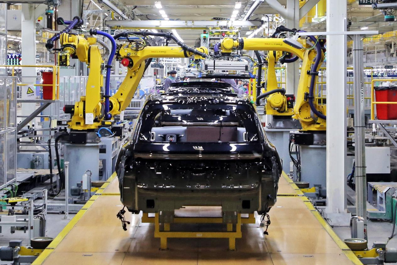 2023年12月10日，江苏常州一汽车基地的生产车间，机器臂在组装新能源汽车。