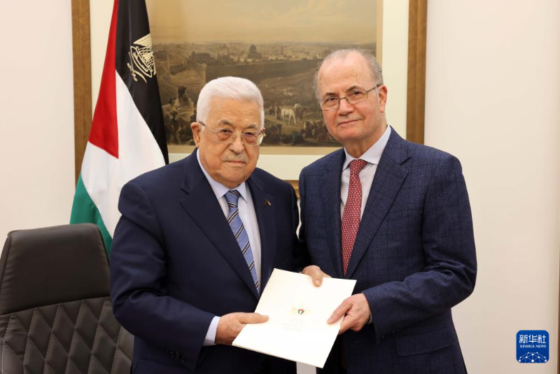 3月14日，在约旦河西岸城市拉姆安拉，巴勒斯坦总统阿巴斯（左）将授权书交到穆罕默德·穆斯塔法手中。（图源：新华社）