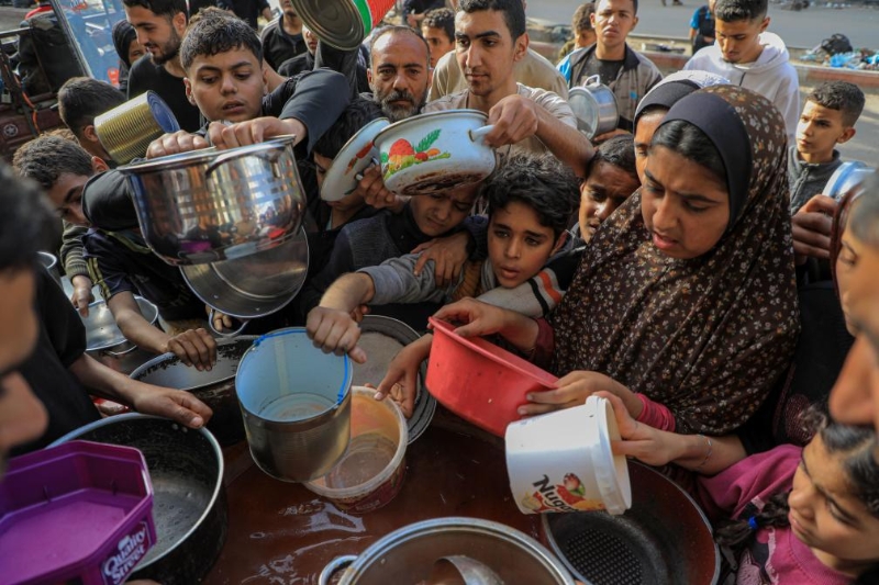 3月30日，巴勒斯坦人在加沙地带南部城市拉法等待领取食物。（图源：新华社）