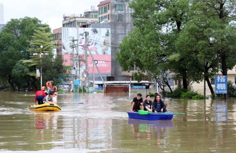 4月21日，广东清远英德市浛洸镇居民在积水的道路上乘船出行。新华社记者 黄国保 摄