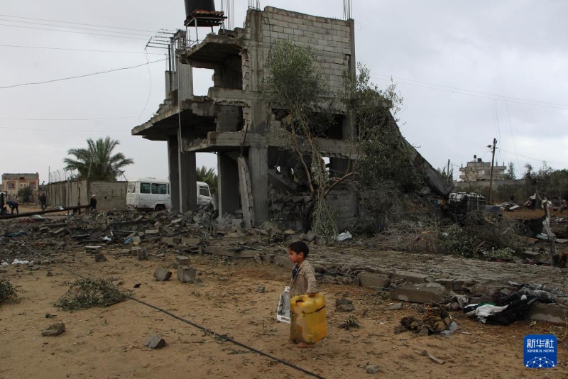 5月6日，在加沙地带南部城市拉法，一名男孩走过以军空袭后的废墟。新华社发（哈立德·奥马尔 摄）
