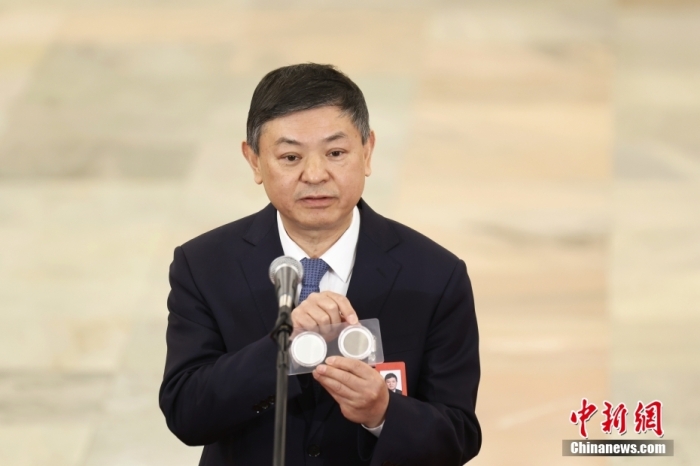 3月8日，十四屆全國人大三次會議第二場“部長通道”集中采訪活動在北京人民大會堂舉行，生態(tài)環(huán)境部部長黃潤秋接受采訪。圖為黃潤秋展示兩塊濾膜來證明北京天氣的變化。<a target='_blank' href='/'>中新社</a>記者 韓海丹 攝