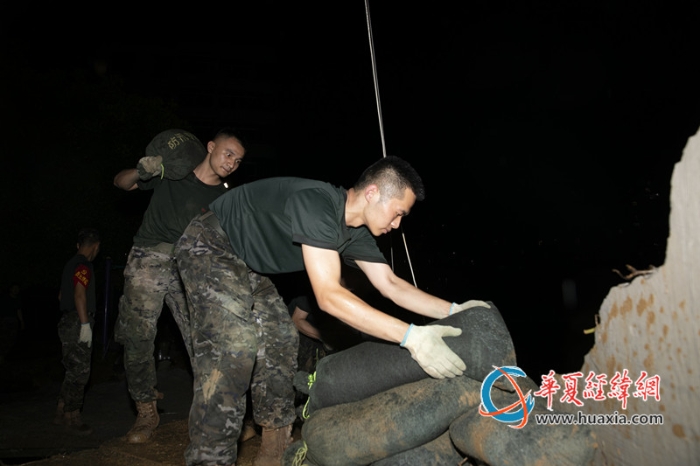 9、2025年7月1日，在广西百色市隆林各族自治县，武警官兵们正在垒筑防汛沙袋加固堤坝。_副本